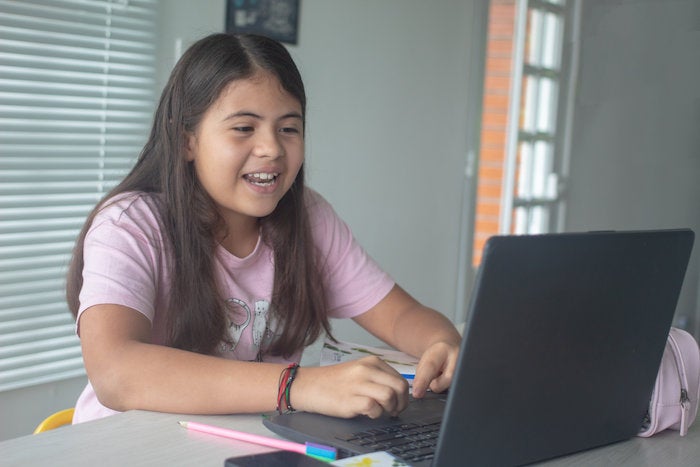 A student participates in a virtual classroom at home. 