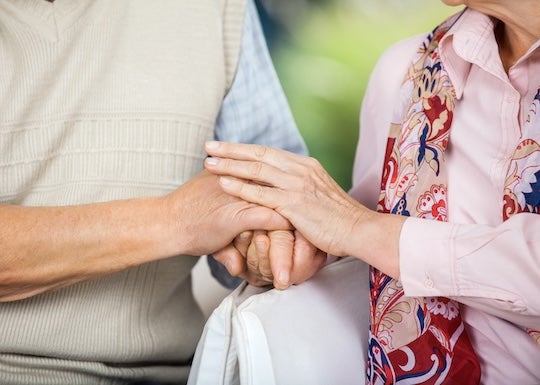 Photo of caregiver and loved one holding hands.