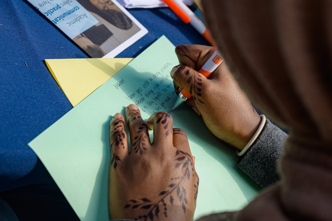 Student writing cards to hospitalized children during Mitzvah Marathon