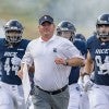 Rice football team running with coach